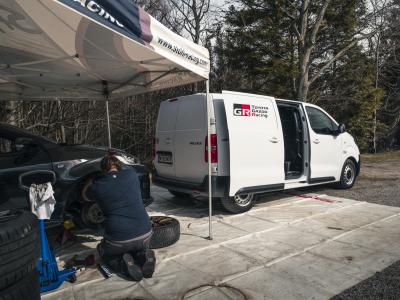 Toyota Proace mit offener Tür. Im Vordergrund wird an einem anderen Auto gearbeitet.